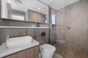 une salle de bain avec un lavabo, des toilettes et une douche dans l'établissement SOP06 Stylish and Cosy 2 Bedroom Apt, à Sydney 23 autres photos
