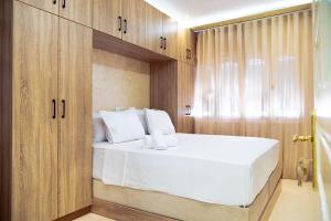 a bedroom with a white bed and wooden cabinets at Dar Belleza in Tangier