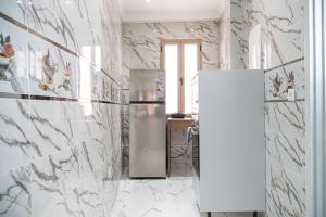 a stainless steel refrigerator in a kitchen with marble walls at Dar Belleza in Tangier