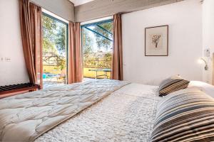 a bedroom with a large bed and a large window at Barbati Beach - Villa Ithika in Barbati