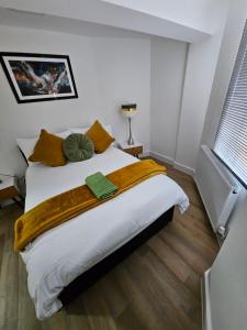 a bedroom with a large white bed with orange pillows at Union House in Stratford-upon-Avon