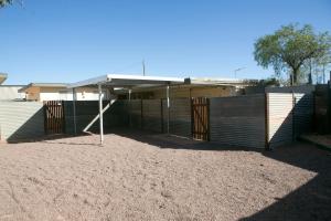 a building with a wooden fence and a canopy at Cave Place Units in Coober Pedy