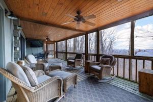 - une terrasse couverte avec des chaises en osier et un ventilateur de plafond dans l'établissement Scenic Getaway - Hot Tub & Mountain Views, à Mentone
