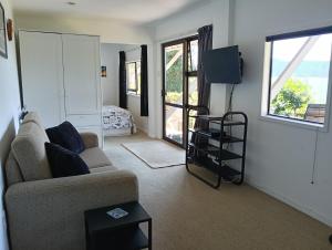a living room with a couch and a television at A Sea View B&B in Picton