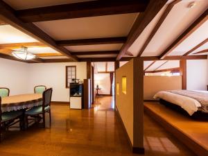 Un dormitorio con una cama y una mesa y sillas. en Auberge A MA FACON, en Kokonoe