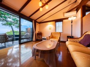 una sala de estar con un sofá y una mesa en Auberge A MA FACON, en Kokonoe