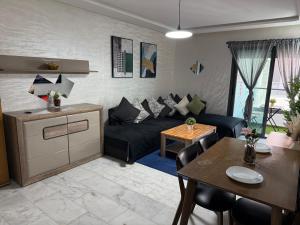 a living room with a black couch and a table at Studio Stadium morocco for family in Mohammedia