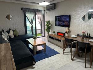 a living room with a couch and a table at Studio Stadium morocco for family in Mohammedia