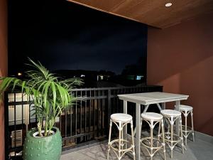 un tavolo e degli sgabelli su un balcone di notte di Stylish CBD Retreat with 3BR,3BA,Balcony,2 Parking a Adelaide