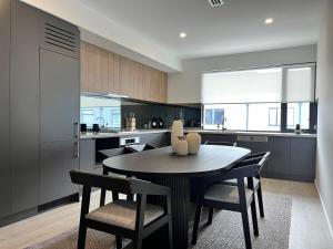 una cucina con un tavolo e sedie in una stanza di Stylish CBD Retreat with 3BR,3BA,Balcony,2 Parking a Adelaide