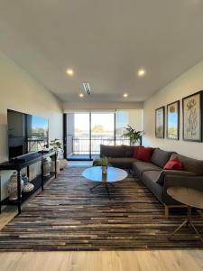 un soggiorno con un divano e un tavolo di Stylish CBD Retreat with 3BR,3BA,Balcony,2 Parking a Adelaide