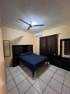 a bedroom with a bed and a ceiling fan at Casa en Manzanillo in Manzanillo
