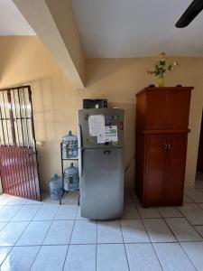 a kitchen with a refrigerator and a wooden cabinet at Casa en Manzanillo in Manzanillo +45 photos