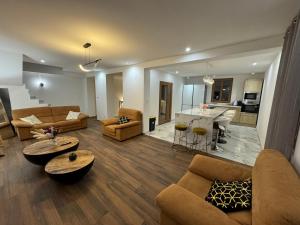 a living room with couches and a table and a kitchen at Villa Segny Chalet in Ségny