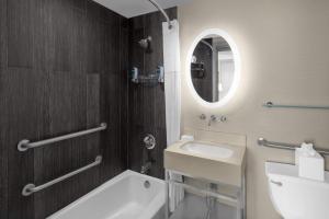 une salle de bain avec un lavabo, des toilettes et un miroir dans l'établissement Solita Soho Hotel, à New York 24 autres photos