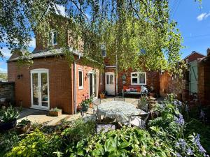 a brick house with a patio in the yard at Spacious Edwardian home in Stroud