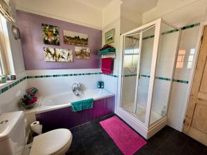 a bathroom with a tub and a toilet and a shower at Spacious Edwardian home in Stroud +31 photos