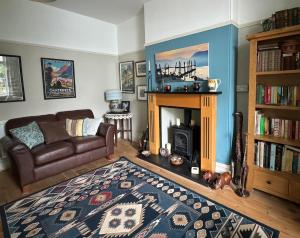 a living room with a couch and a fireplace at Spacious Edwardian home in Stroud
