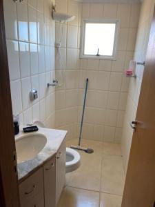 ein Badezimmer mit Toilette und Waschbecken und einem Fenster in der Unterkunft Apartamento familiar 2 quartos, próximo ao centro in Sao Jose do Rio Preto