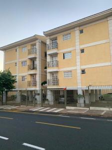 ein Gebäude mit einem Zaun neben einer Straße in der Unterkunft Apartamento familiar 2 quartos, próximo ao centro in Sao Jose do Rio Preto