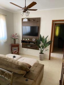 ein Wohnzimmer mit Couch und Flachbildfernseher in der Unterkunft Apartamento familiar 2 quartos, próximo ao centro in Sao Jose do Rio Preto