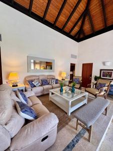 ein Wohnzimmer mit Sofa und Tisch in der Unterkunft Villa in Cap Cana 4BR Green Village in Punta Cana + 51 Fotos
