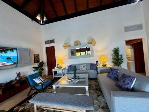 ein Wohnzimmer mit Sofa und Tisch in der Unterkunft Villa in Cap Cana 4BR Green Village in Punta Cana
