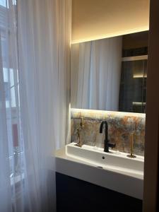 ein Badezimmer mit Waschbecken und Spiegel in der Unterkunft Border Bliss - Private Room with Bathroom in a Cozy Home in Kerkrade + 30 Fotos