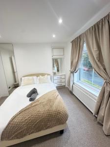 a bedroom with a large bed and a window at Entire luxury home in Manchester in Bury