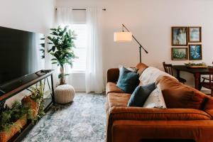 a living room with a brown couch and a tv at Mid-Term Discounts - Near Downtown, UGA, Hospital in Athens