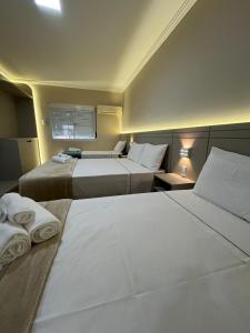 une chambre d'hôtel avec deux lits et une fenêtre dans l'établissement Premier Palace Hotel, à Araranguá