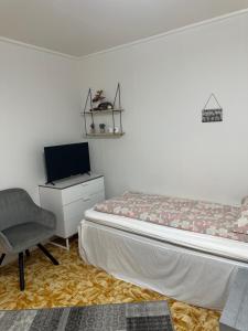 a bedroom with a bed and a chair and a tv at Anabranch Bliss in Øverbygd