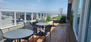 a balcony with tables and chairs on a building at Dream Apartment-Rooftop, Pool, Mountain & Sea View in Capão da Canoa