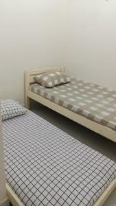 zwei Betten nebeneinander in einem Zimmer in der Unterkunft Guest House Gani Syariah in Paret