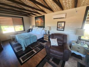 a bedroom with a bed and a couch and a chair at Quail Covey Cottage in Hereford Airport