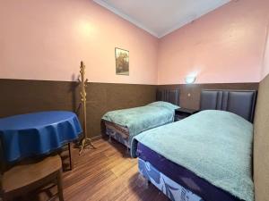 a room with two beds and a table in it at Hostal Tambo de Oro in La Paz +35 photos