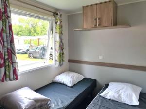 a small room with a bed and a window at Mobil-home TV 3Ch 6Pers La Tranche-sur-Mer O'Gliss park 430S in Angles +41 photos