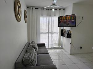 un salon avec un canapé et une télévision à écran plat dans l'établissement excelente Cobertura no centro de Bertioga, à Bertioga