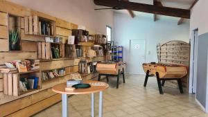 a room with a table and chairs and book shelves at Mobil-home TV 3Ch 6Pers La Tranche-sur-Mer O'Gliss park 430S in Angles