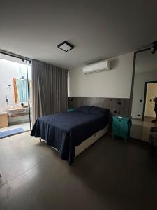 une chambre avec un grand lit et un miroir dans l'établissement Casa Astral, à Uberlândia
