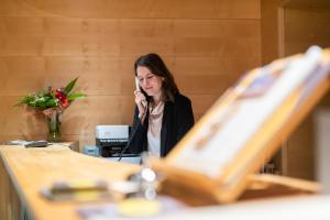 una mujer hablando por un celular en una oficina en Hotel Suite Inn, en Udine