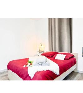 a bedroom with a red and white bed with flowers on it at Studio des Trois Frontières in Saint-Louis