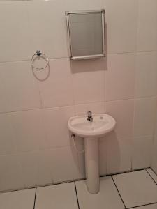 a white bathroom with a sink and a mirror at Recanto feliz in São Thomé das Letras