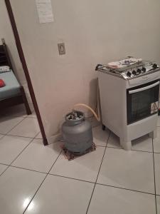 a kitchen with a stove and a pot on the floor at Recanto feliz in São Thomé das Letras +1 photo