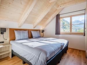 a large bed in a room with a large window at Sperlingnest in Donnersbachwald
