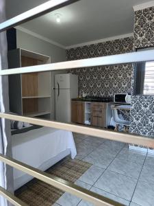 a room with a bed and a kitchen with a refrigerator at Aconchegante com Ótimo preço, Vem conferir! in Cascavel