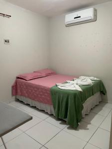 ein Schlafzimmer mit einem Bett mit einer grünen Decke in der Unterkunft Apartamento aconchegante perto da rodoviária in Teresina