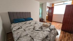 une chambre avec un grand lit avec des oreillers bleus dans l'établissement Sierra Nevada 2, à Ibarra