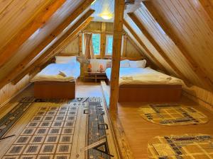 two beds in a room with a attic at Villa Bilugu in Valea de Brazi