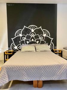 - une chambre avec un lit doté d'une tête de lit en noir et blanc dans l'établissement Studio Astral, à Uberlândia